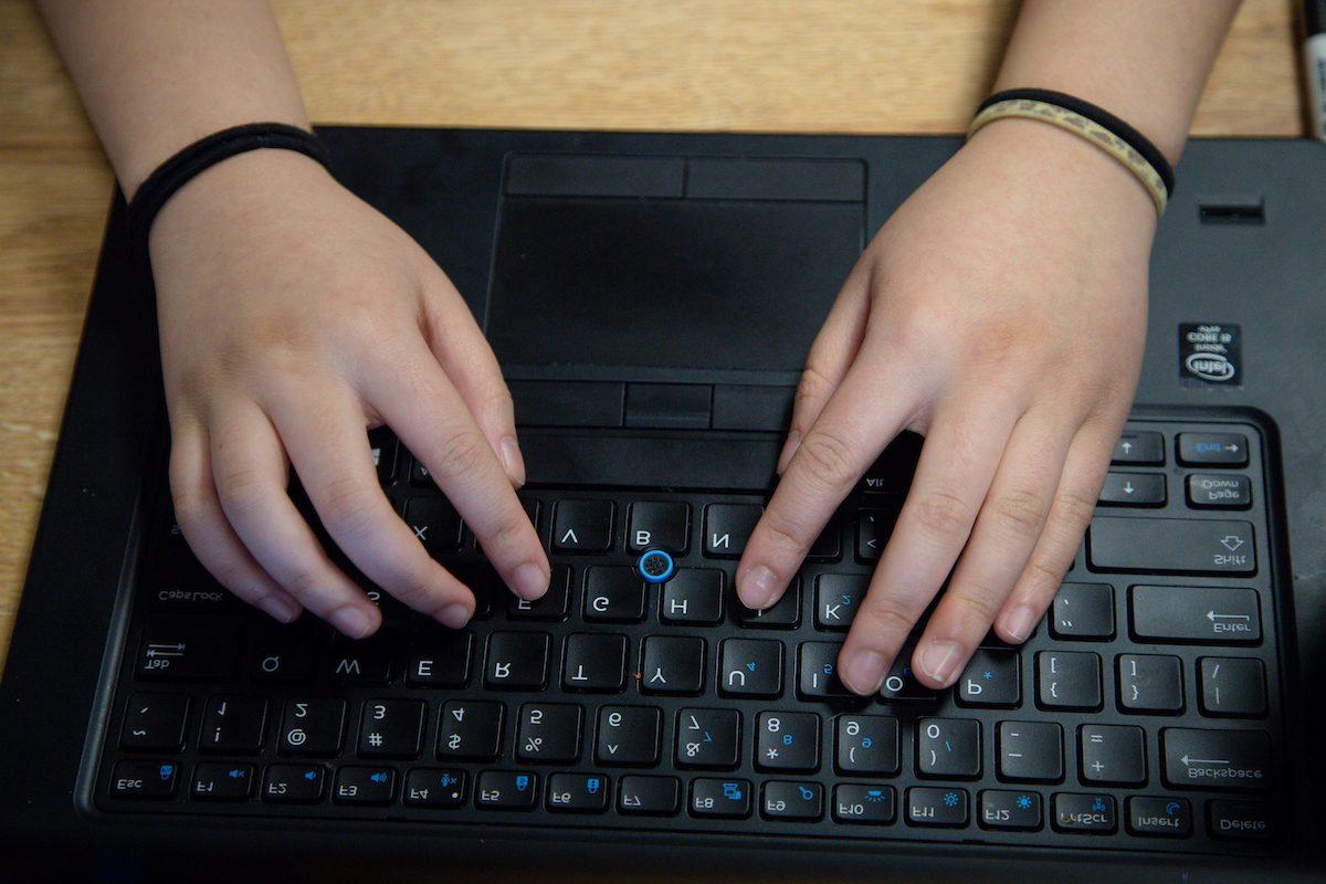 从上方看学生的手在键盘上打字