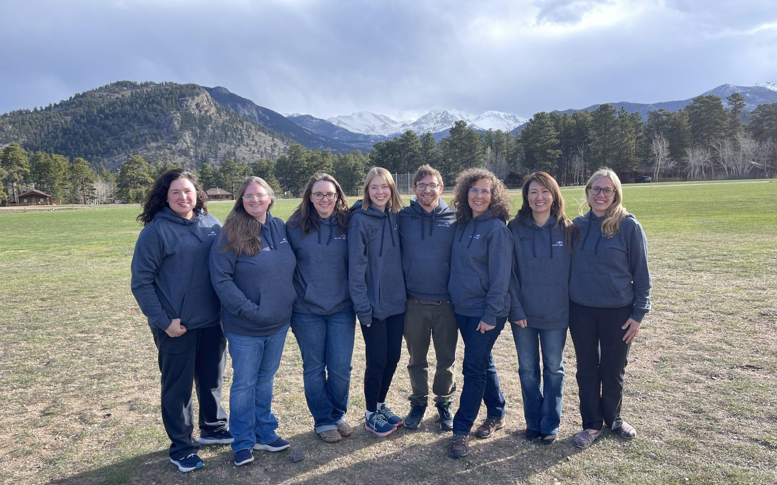 8名在线学习团队成员的照片，背景是落基山脉.